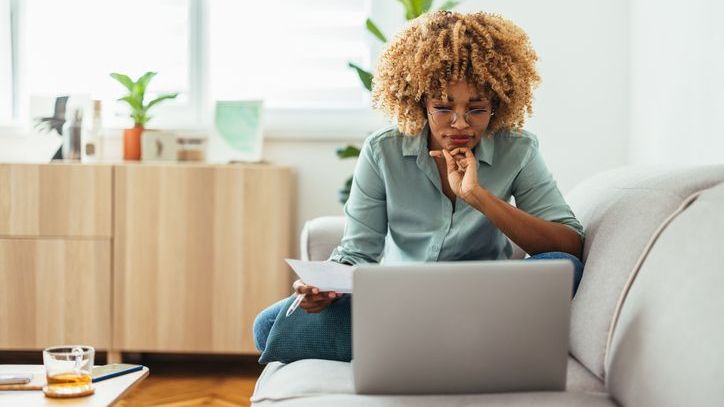 A woman reviews her company's employee stock purchase plan on her laptop at home.